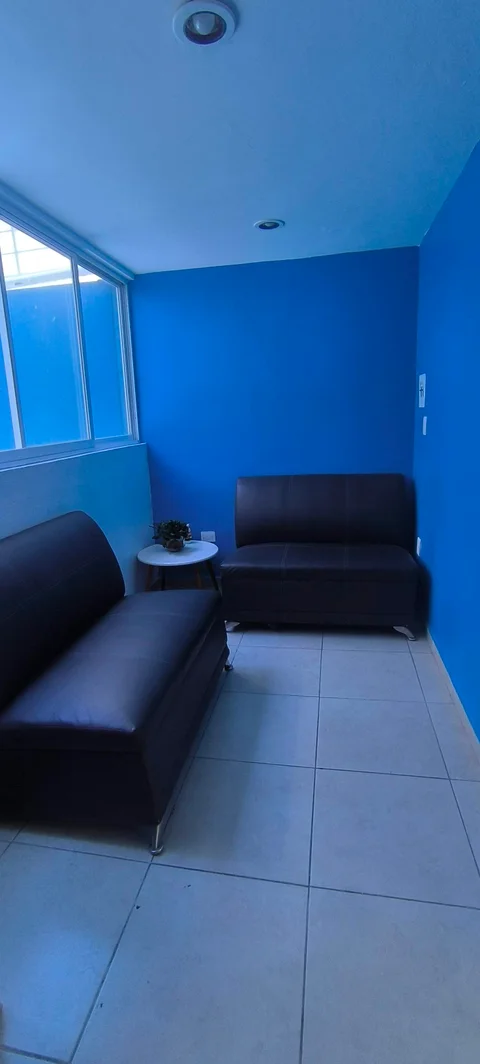 Sala de espera con dos sillones y ventana