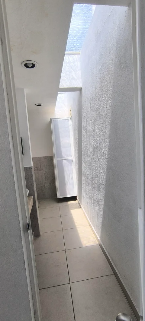 Pasillo hacia el baño común, con tragaluz