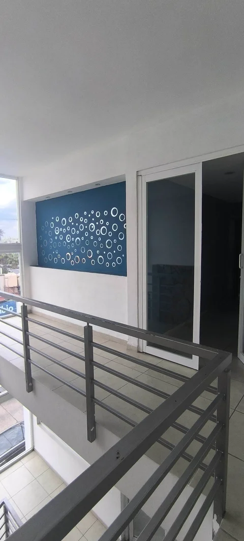 Vestíbulo del piso con barandal y puerta de vidrio